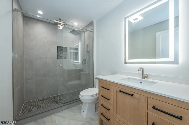 a bathroom with a sink toilet a mirror and shower