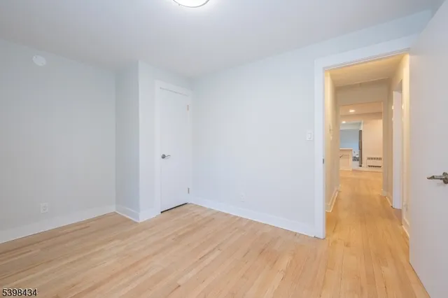 a view of a room with wooden floor and a bathroom