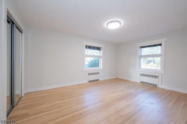 an empty room with windows and closet