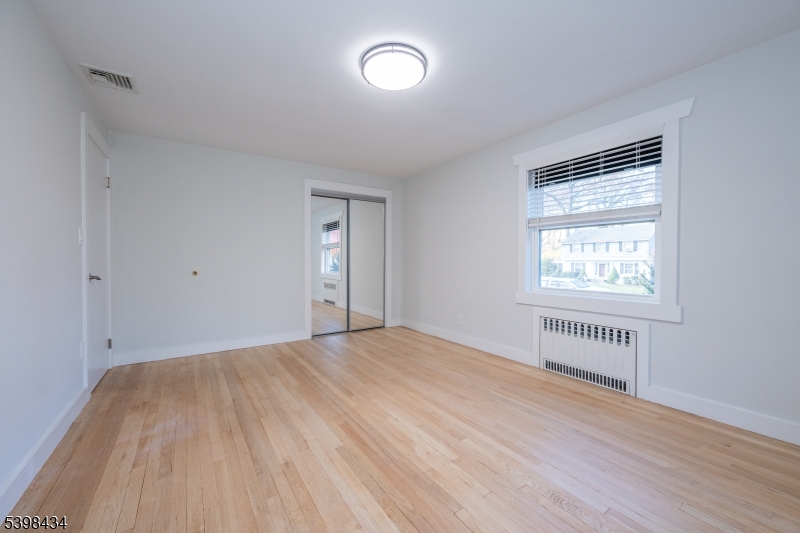 7 Oak Tree Lane Little Falls, NJ 07424 - Photo 29 of 46 a view of an empty room with a window and wooden floor