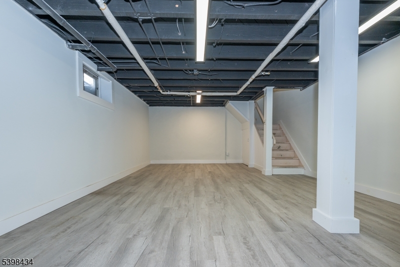 7 Oak Tree Lane Little Falls, NJ 07424 - Photo 31 of 46 an empty room with wooden floor and stairs
