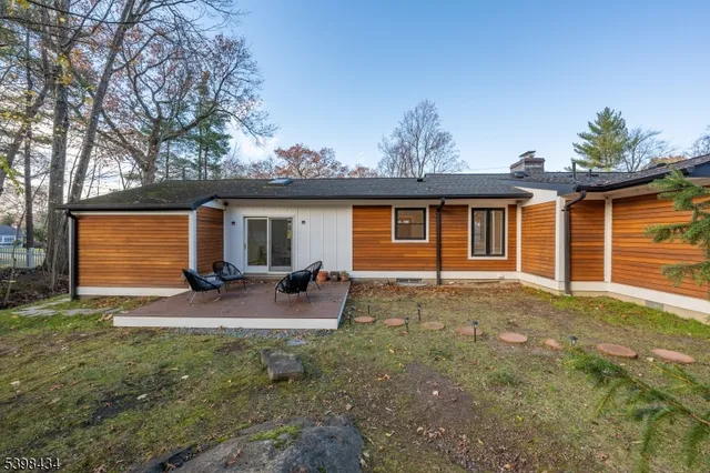 a view of a house with backyard and sitting area