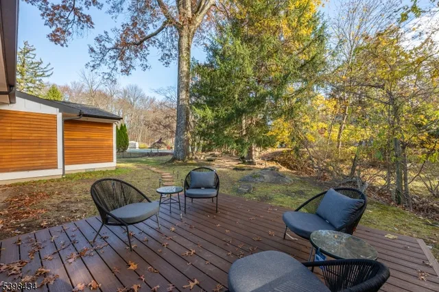a view of backyard with seating space and trees