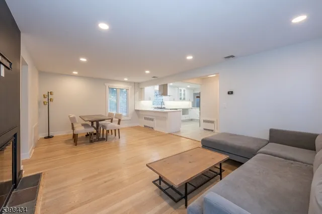 a living room with furniture and a table with wooden floor