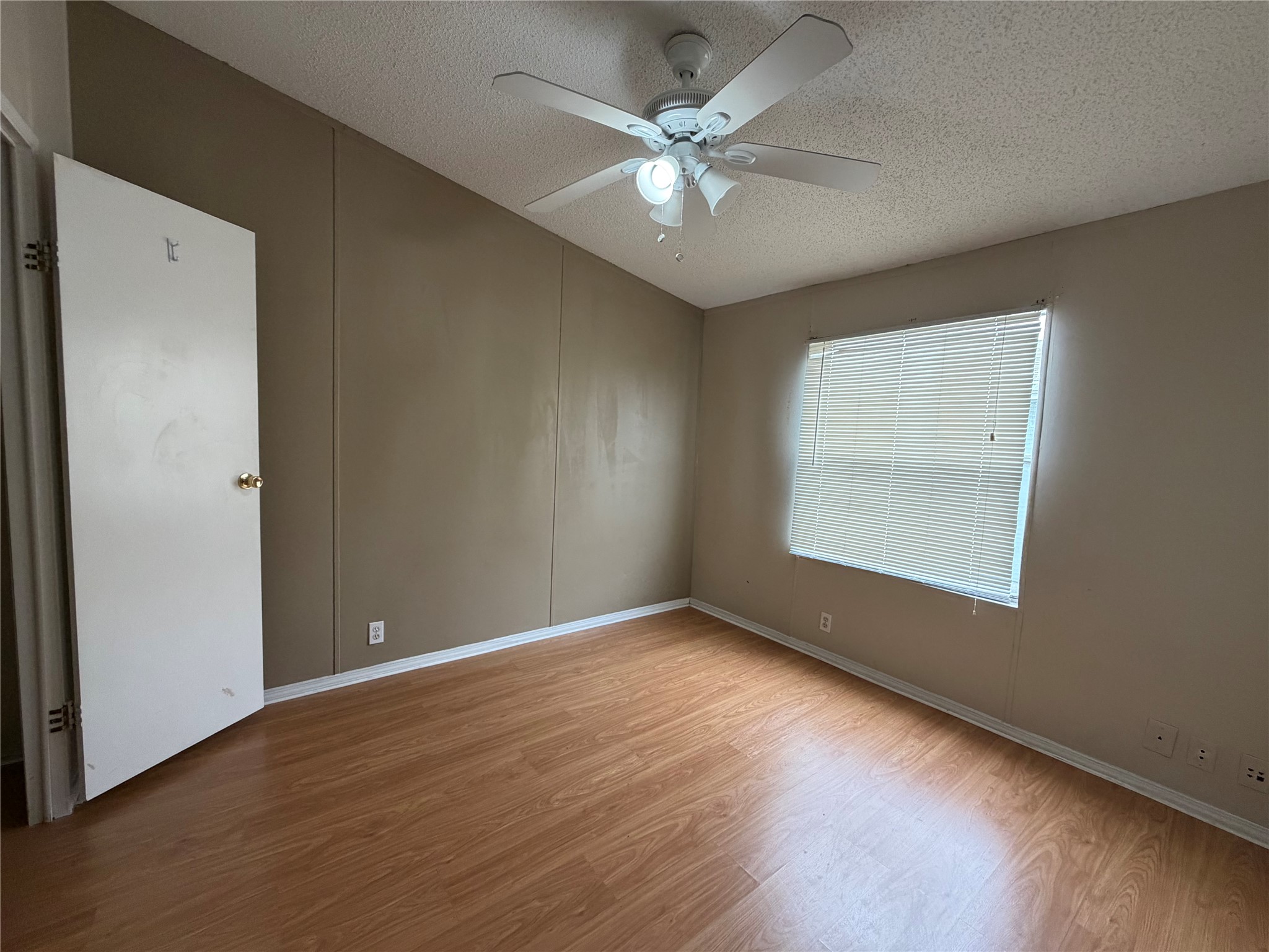 12609 Dessau Road, Unit 410 Austin, TX 78754 - Photo 5 of 11 Interior room featuring wood-finish flooring, a white ceiling fan with integrated lighting, a window with horizontal blinds, and a white baseboard trim