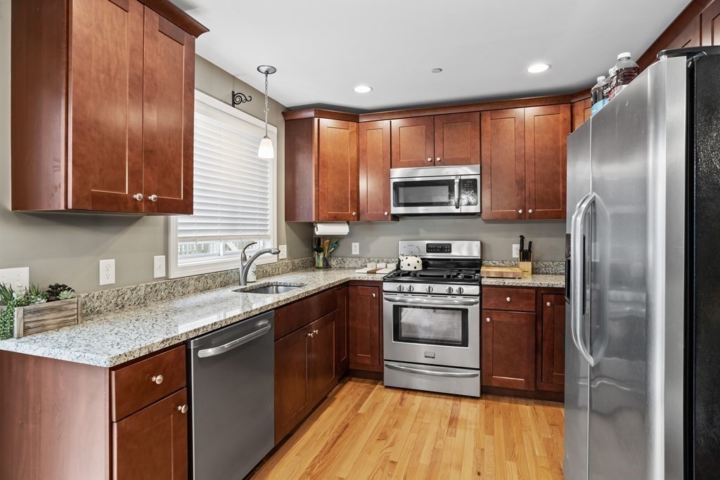 311 Littleton Road, Unit 20 Chelmsford, MA 01824 - Photo 10 of 35 a kitchen with stainless steel appliances granite countertop a stove a sink dishwasher a refrigerator and a microwave oven