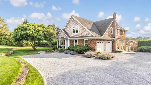 a front view of a house with a yard and potted plants
