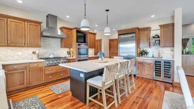 a kitchen with stainless steel appliances a dining table chairs sink and cabinets