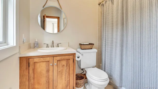 a bathroom with a toilet a sink and mirror