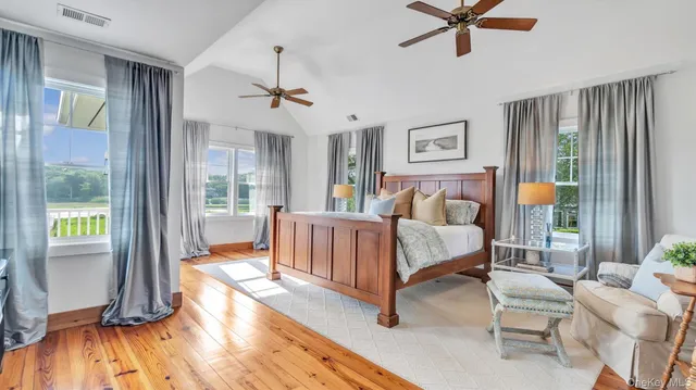 a bedroom with a bed and a view of bedroom with wooden floor