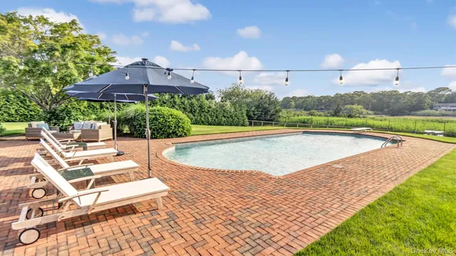 swimming pool view with a seating space