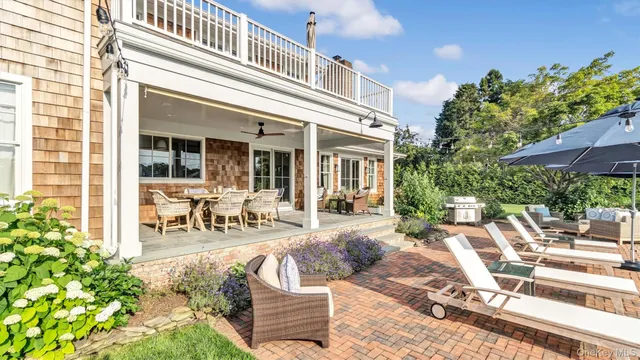 a view of a patio with table and chairs potted plants and floor to ceiling window and potted plants