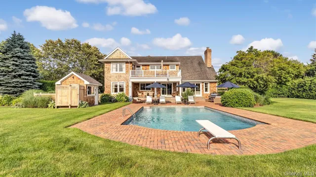 a view of a house with swimming pool and sitting area