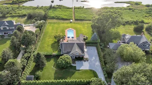 an aerial view of a house with a yard and lake view