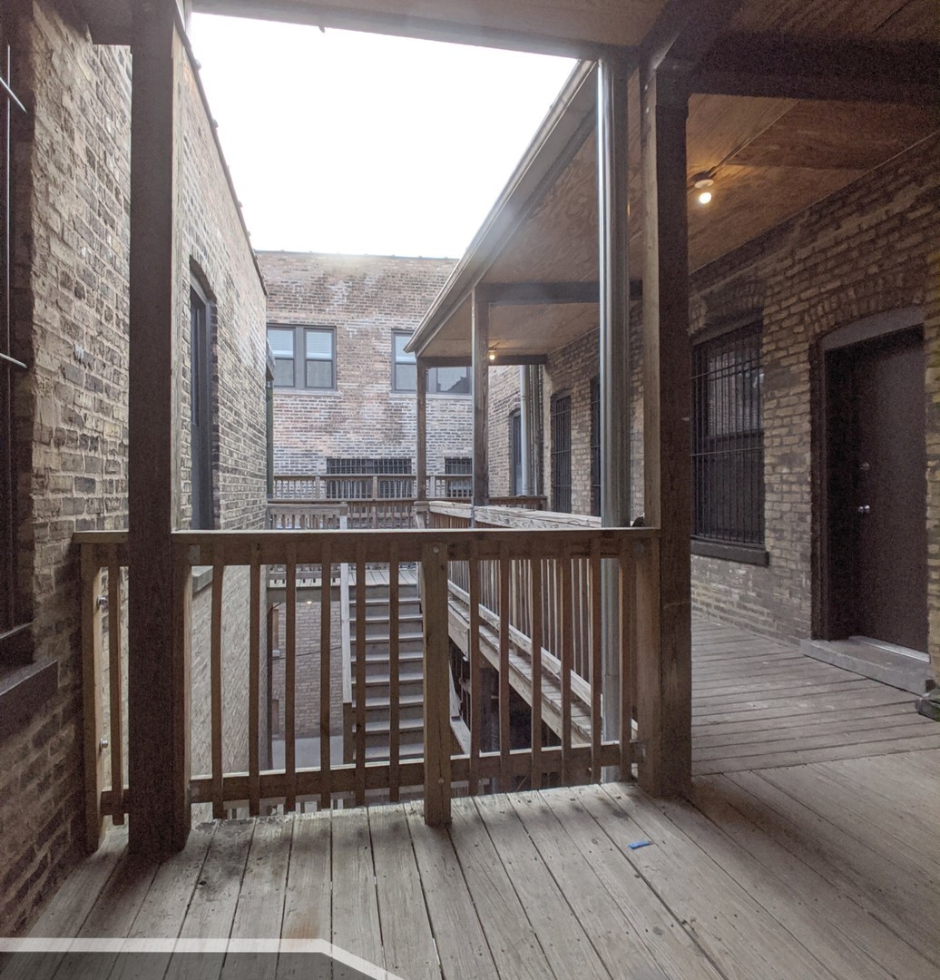 3401 West Fullerton Avenue, Unit 2 Chicago, IL 60647 - Photo 20 of 20 a view of a balcony with wooden floor and fence