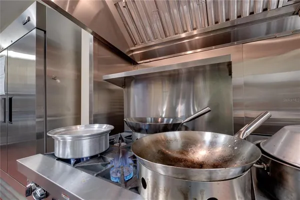 a room with a chair and white cabinets