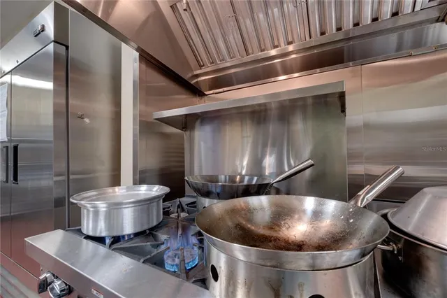 a room with a chair and white cabinets