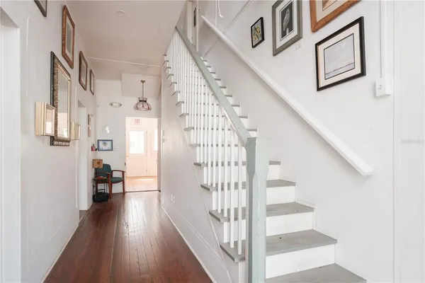 a view of staircase with lots of frames on wall and a window