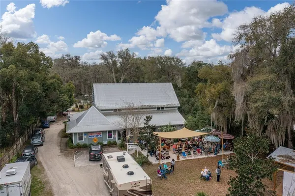 an aerial view of a house with swimming pool and trees in the background