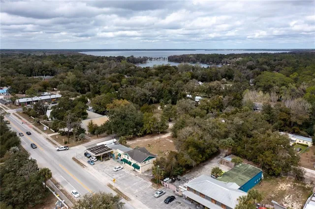 an aerial view of a house with a yard and mountain view in back