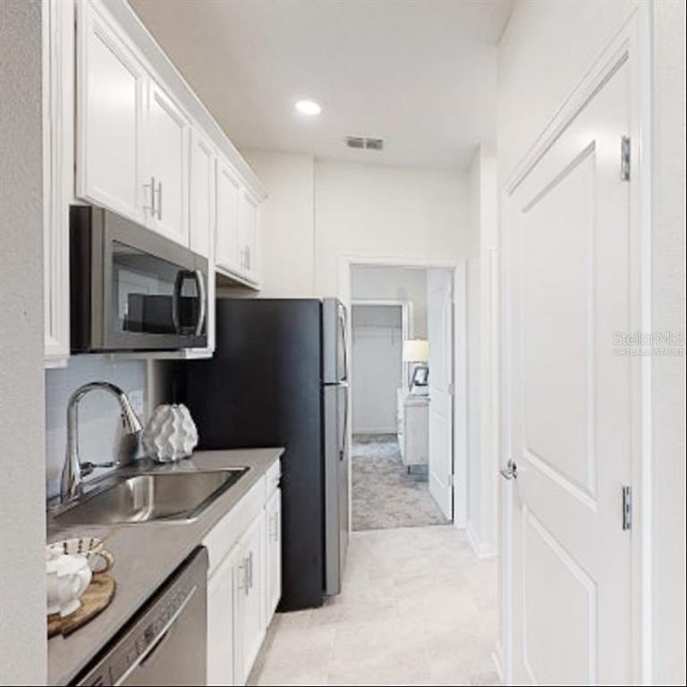 2455 Bluestone Road Haines City, FL 33844 - Photo 7 of 14 a kitchen with granite countertop a refrigerator stove and sink