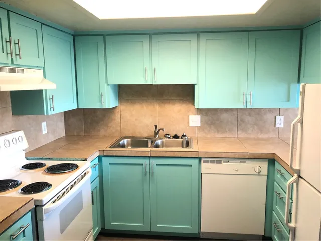 a kitchen with a sink and a stove top oven