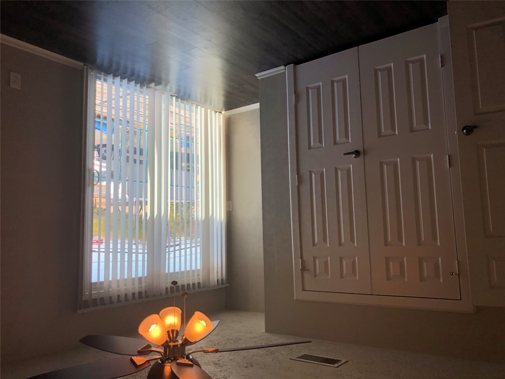 7302 Duval Street, Unit 141 Austin, TX 78752 - Photo 9 of 14 an empty room with wooden floor and windows with curtains