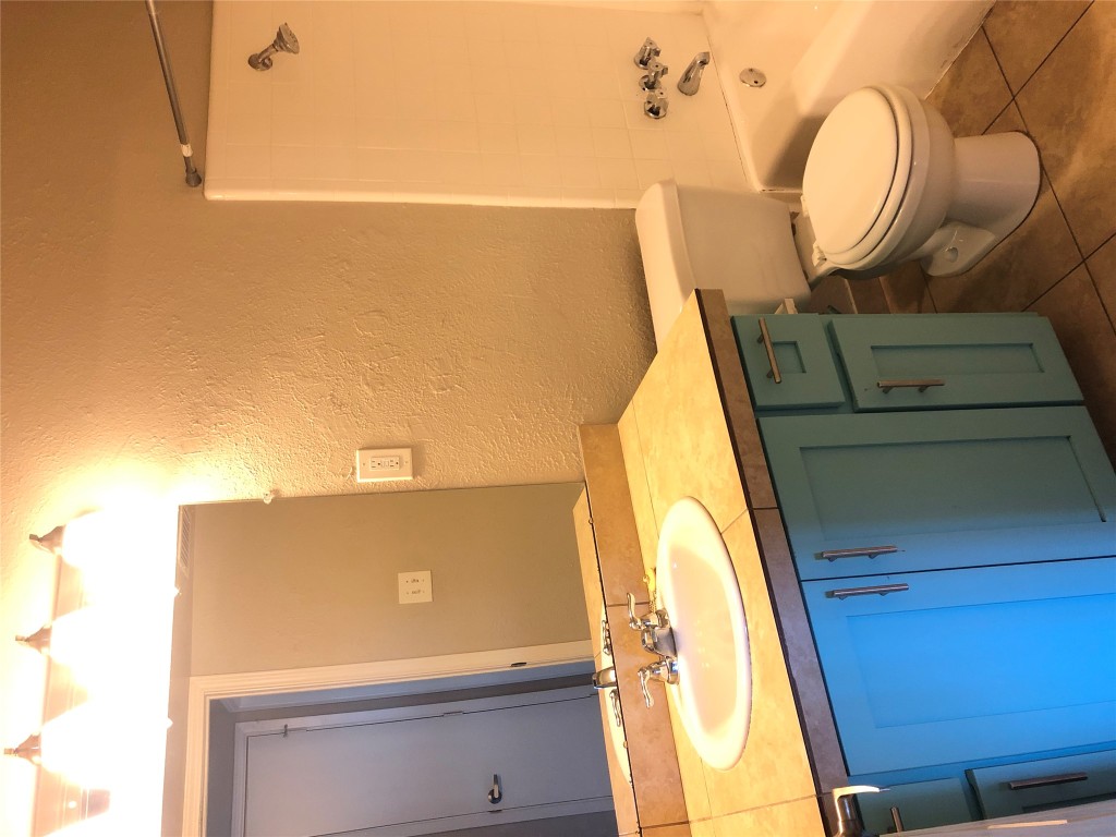 7302 Duval Street, Unit 141 Austin, TX 78752 - Photo 10 of 14 a bathroom with a granite countertop sink toilet and shower