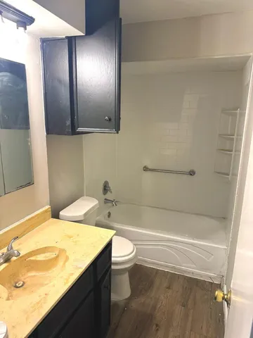 a bathroom with a granite countertop sink toilet and shower