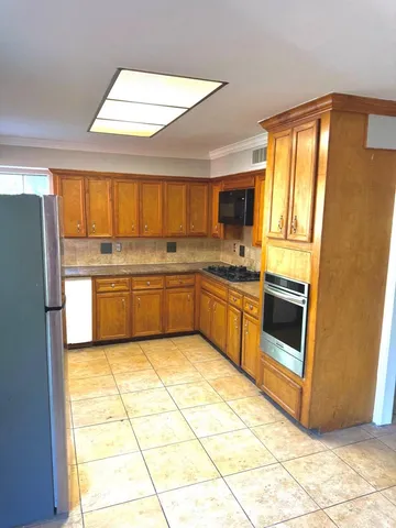 a kitchen with stainless steel appliances granite countertop a stove a sink and a refrigerator