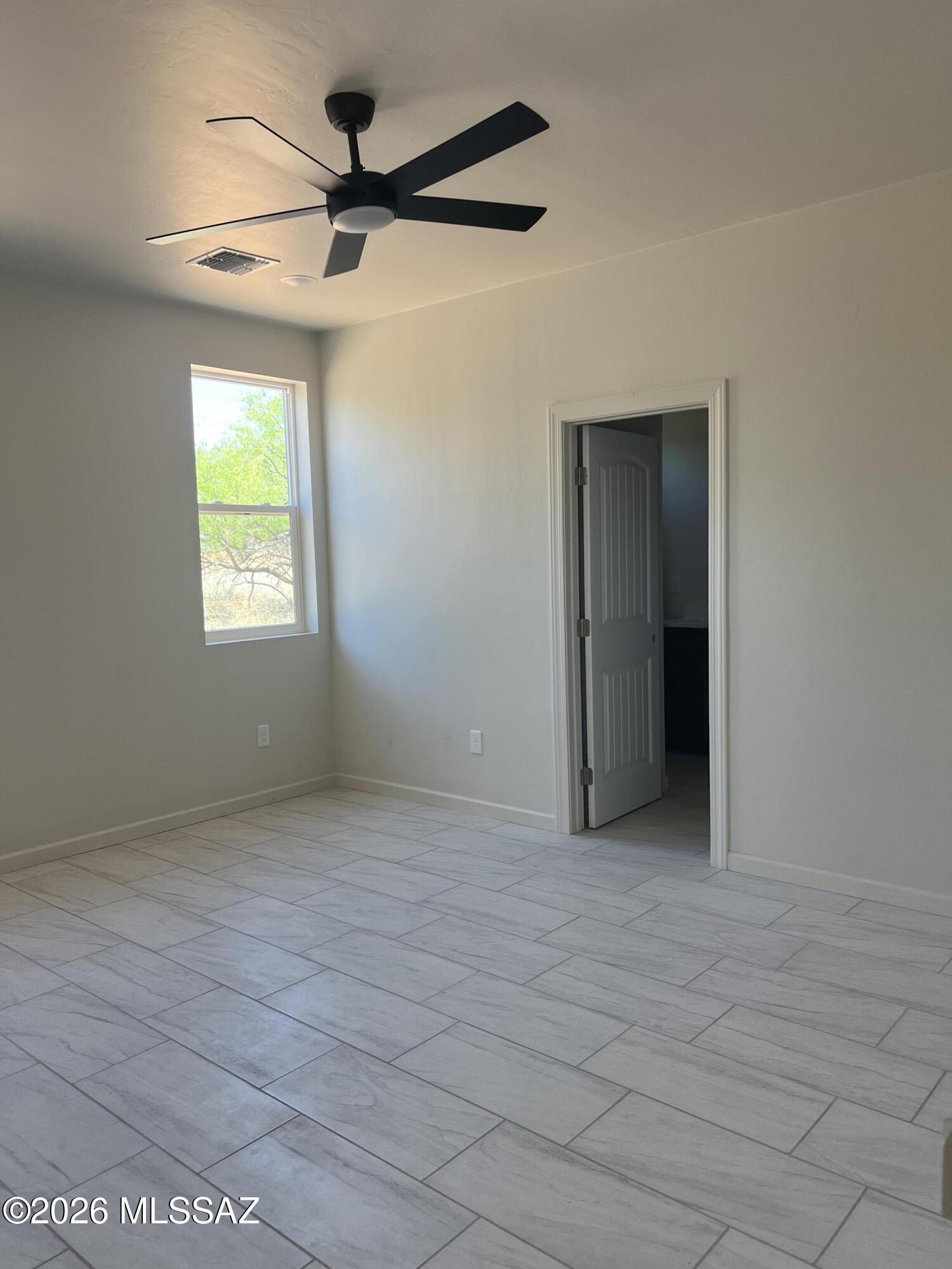 1501 Circulo Sombrero Rio Rico, AZ 85648 - Photo 16 of 26 en empty room with windows and a ceiling fan