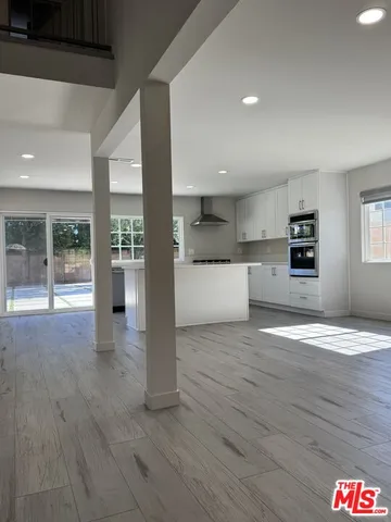a view of a kitchen with wooden floor and a ceiling fan