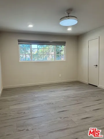 an empty room with wooden floor and a window
