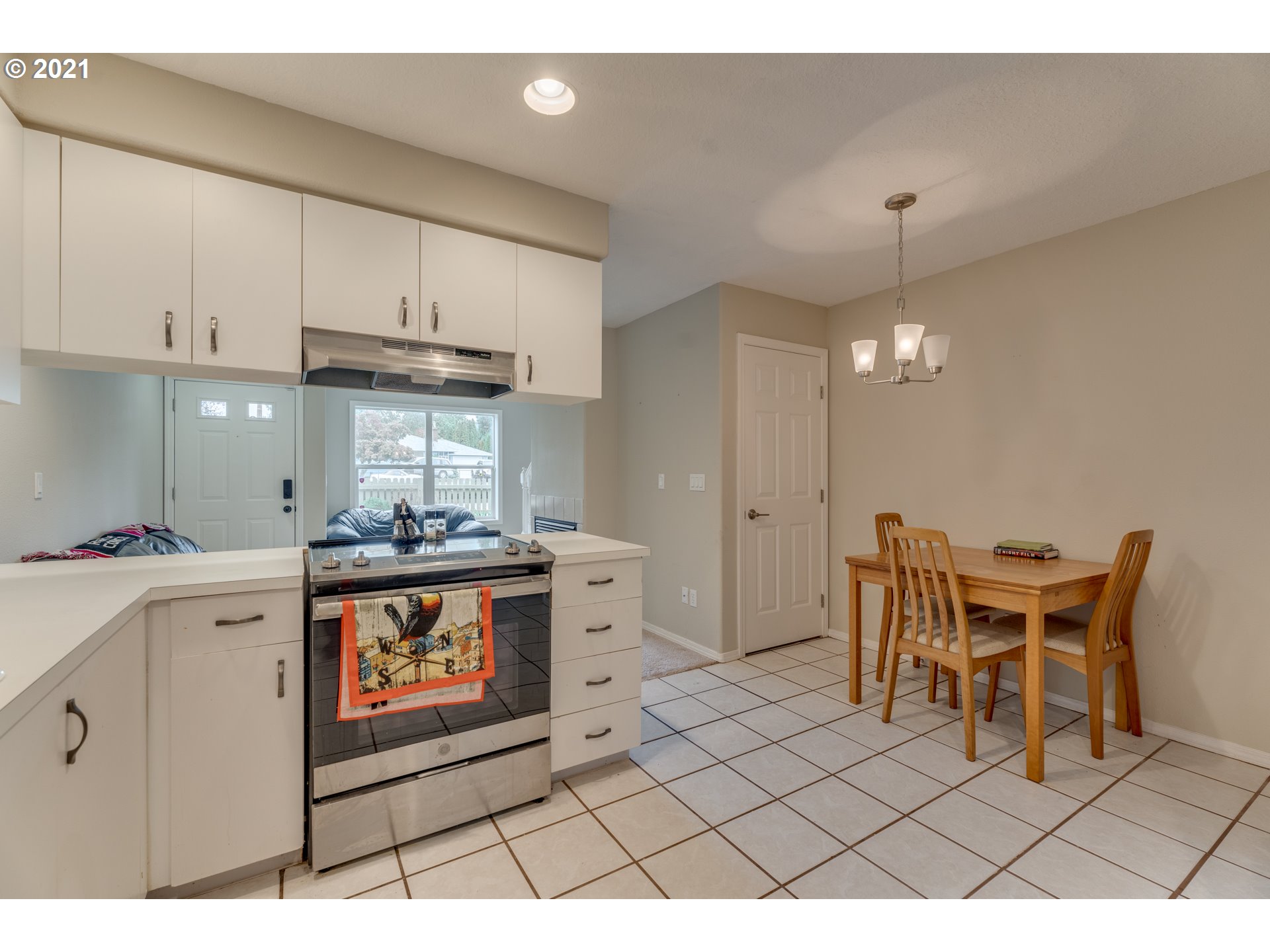 14134 East Burnside Street, Unit 4 Portland, OR 97233 - Photo 12 of 27 a kitchen with stainless steel appliances a stove a sink cabinets and a dining table