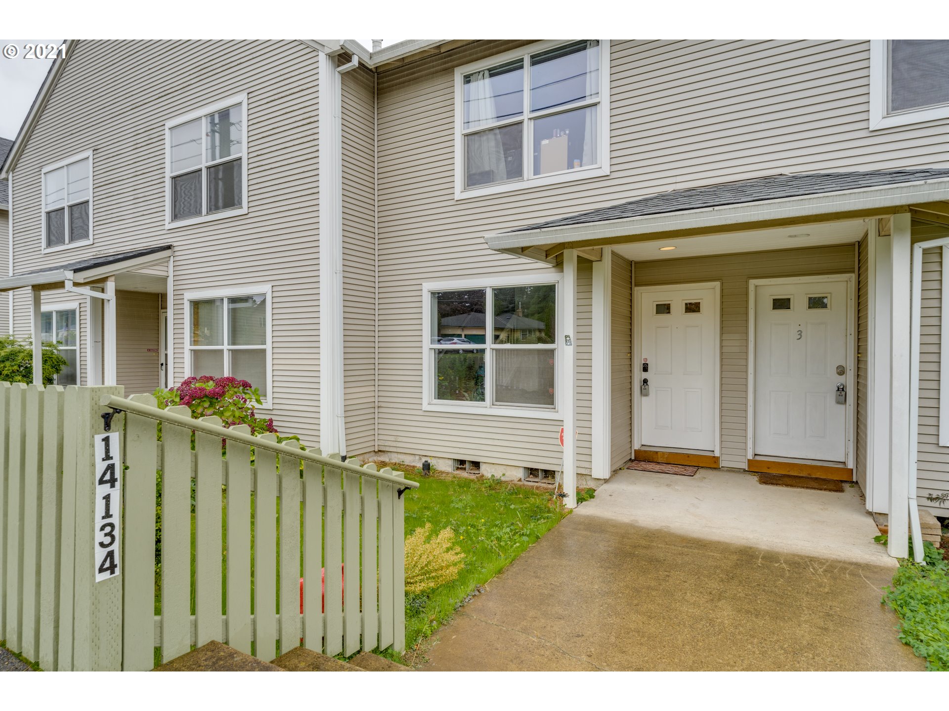 14134 East Burnside Street, Unit 4 Portland, OR 97233 - Photo 25 of 27 a view of a house with a small yard and wooden fence