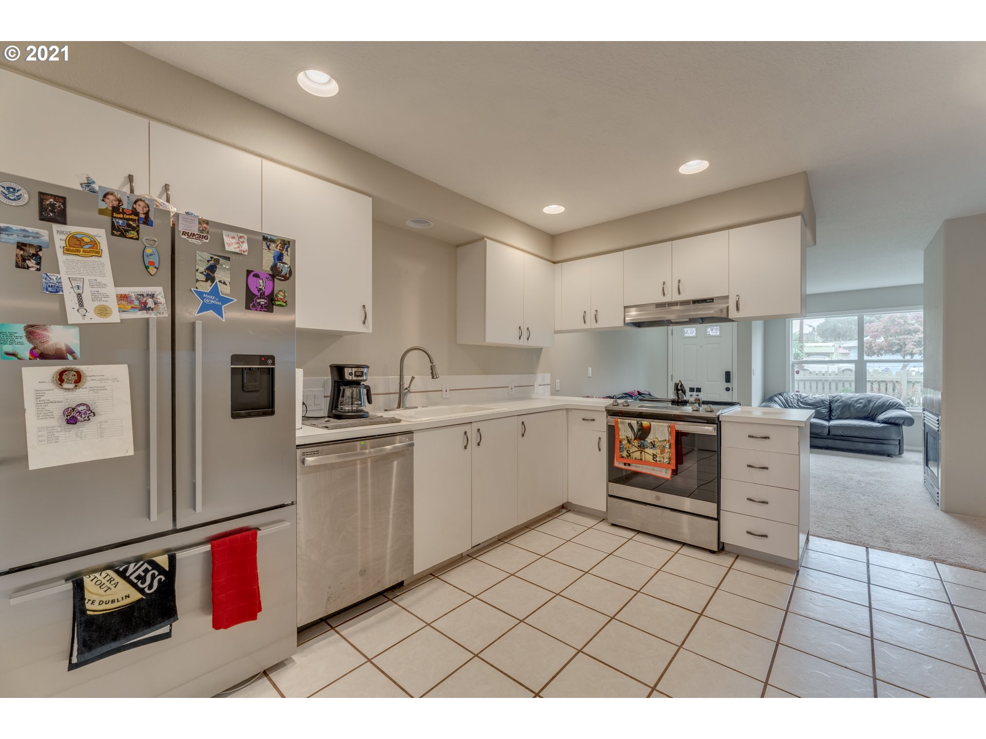 14134 East Burnside Street, Unit 4 Portland, OR 97233 - Photo 10 of 27 a kitchen with a refrigerator and white cabinets