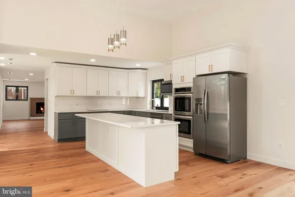 a kitchen with a refrigerator stove and wooden floor