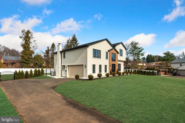 a view of a white house with a big yard and large trees