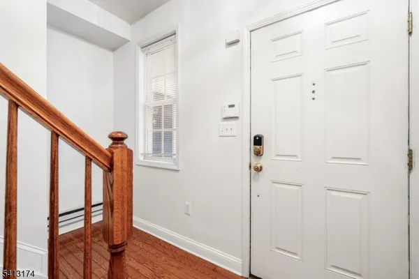 a view of a hallway with wooden floor and staircase