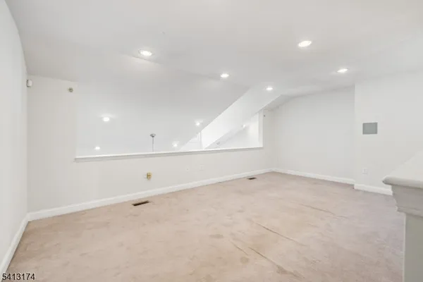 an empty room with cabinet and windows