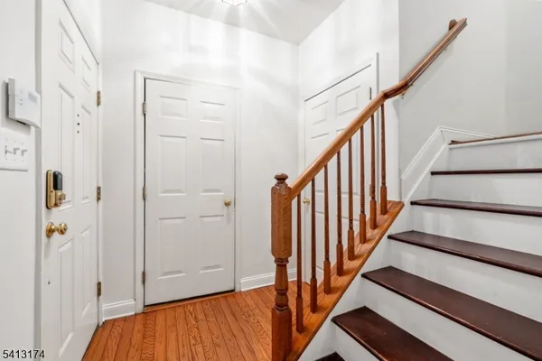 a view of a hallway with wooden floor and staircase