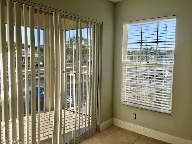 142 Santa Clara Drive, Unit 7 Naples, FL 34104 - Photo 36 of 41 Doorway to outside featuring baseboards, tile patterned flooring, and plenty of natural light