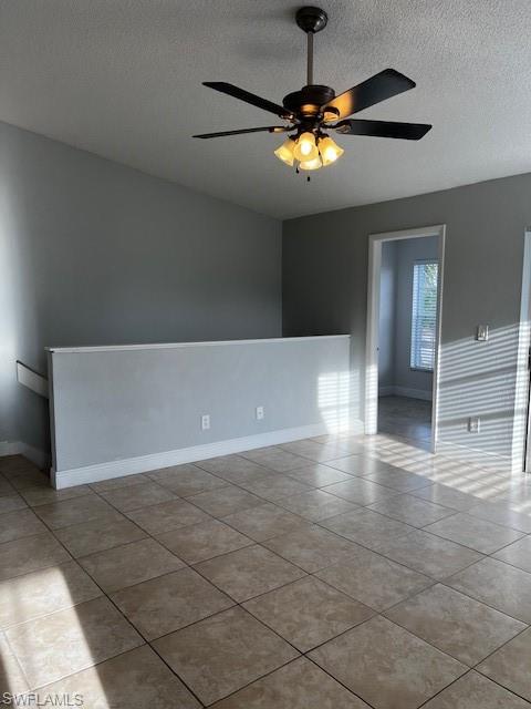 142 Santa Clara Drive, Unit 7 Naples, FL 34104 - Photo 5 of 41 Spare room with tile patterned floors, baseboards, ceiling fan, and a textured ceiling