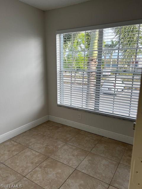 142 Santa Clara Drive, Unit 7 Naples, FL 34104 - Photo 9 of 41 Spare room with baseboards, light tile patterned floors, and a wealth of natural light