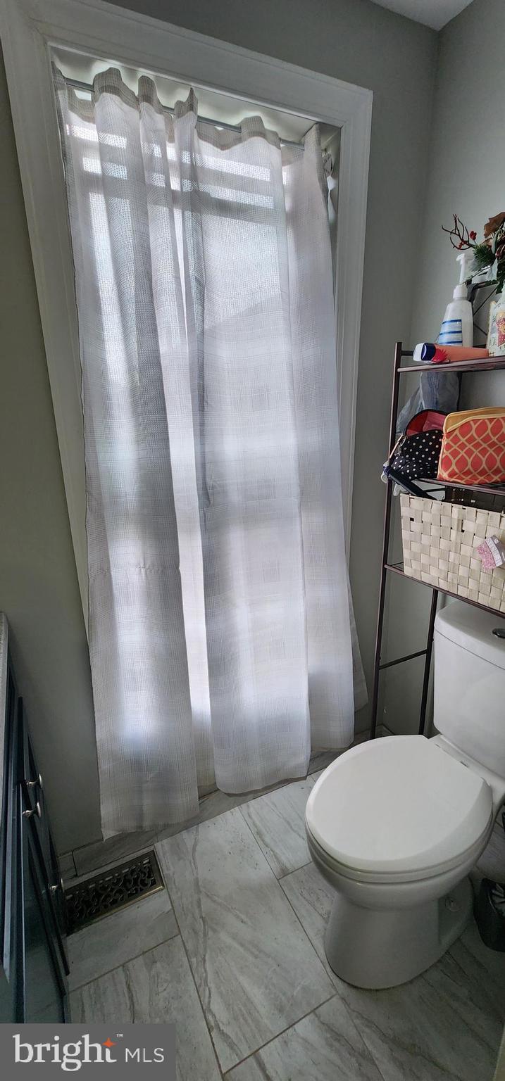 234 Orange Street Reading, PA 19602 - Photo 14 of 18 a white toilet sitting next to a shower