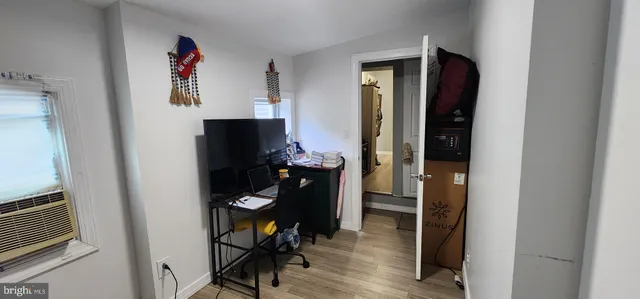 a view of a hallway with wooden floor and furniture