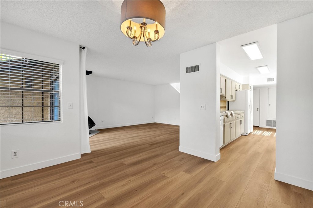 4140 Workman Mill Road, Unit 253 Whittier, CA 90601 - Photo 14 of 63 a view of an empty room with wooden floor and a window