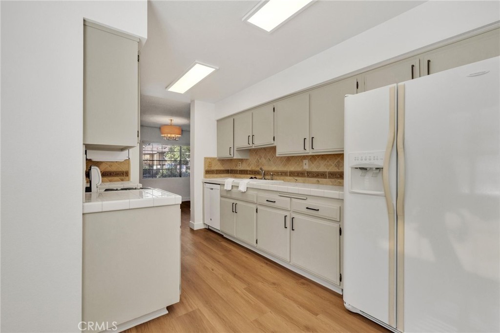 4140 Workman Mill Road, Unit 253 Whittier, CA 90601 - Photo 6 of 63 a kitchen with white cabinets and white stainless steel appliances
