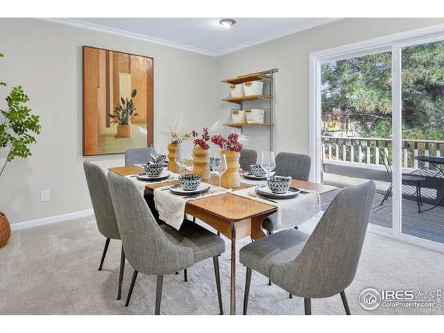 a dining room with furniture a rug and a potted plant