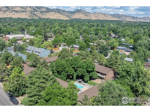 an aerial view of a house with yard and lake view in back